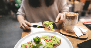 woman eating avocado which is a good source of healthy fats